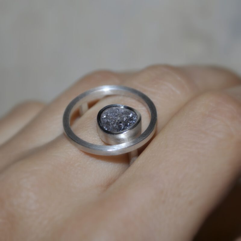 Hand mit Ring "Eingerahmt" aus Silber mit Achatkristall am Mittelfinger