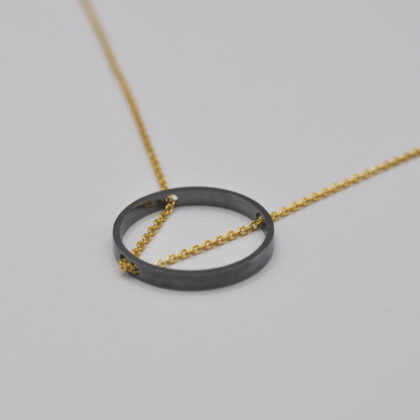goldene Kette mit schwarzem Kreis als Anhänger