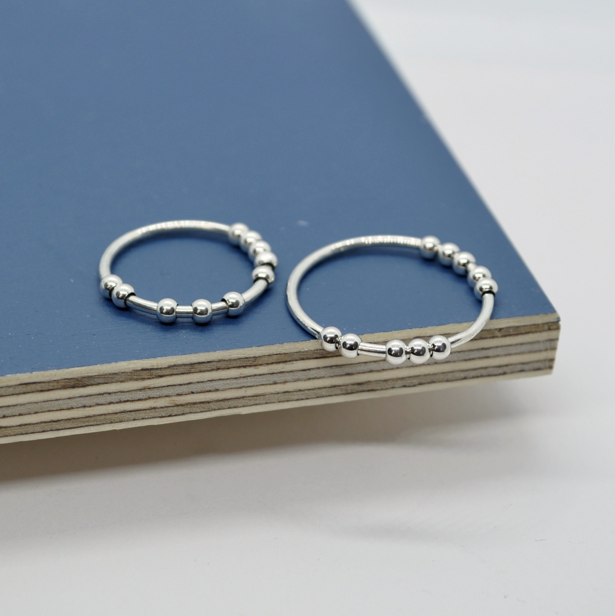 Zwei Anxiety Ringe, Silberringe "Ausgespielt" mit glatten Kugeln auf blauen Brettern