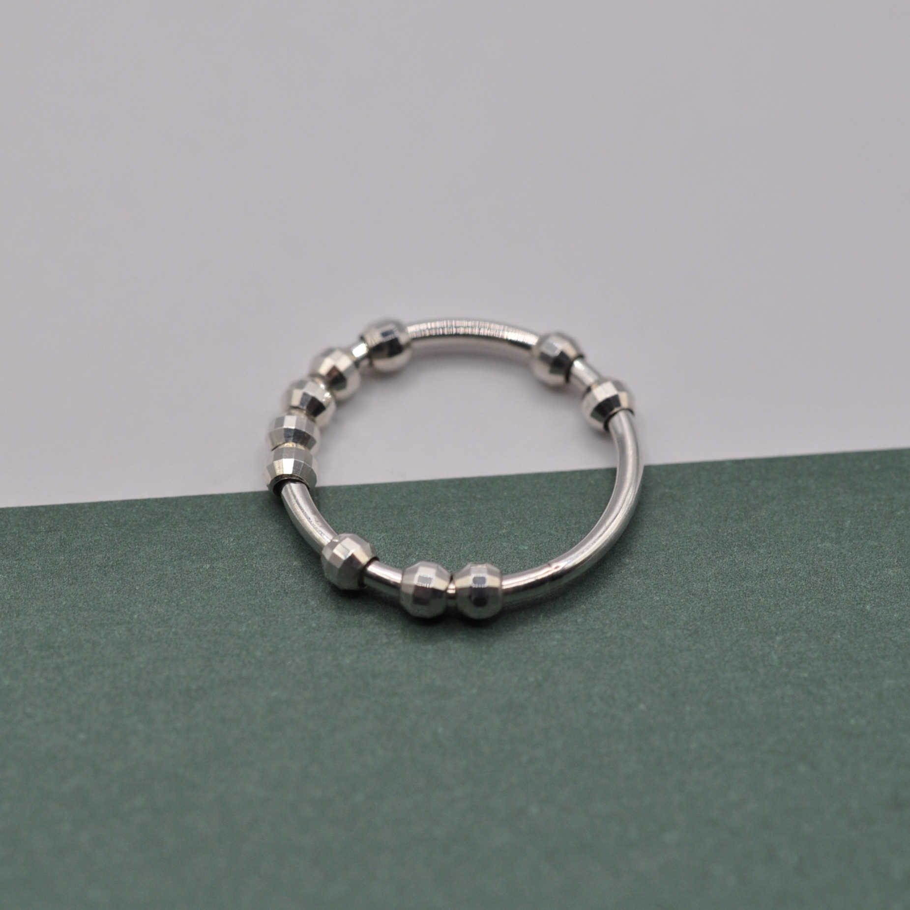 Anxiety Ringe, Silberringe "Ausgespielt" mit "Disco" Kugeln auf grüner Fläche