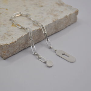 Geöffnetes Armband aus Silber mit ovalem Verschluss liegt auf einer Platte