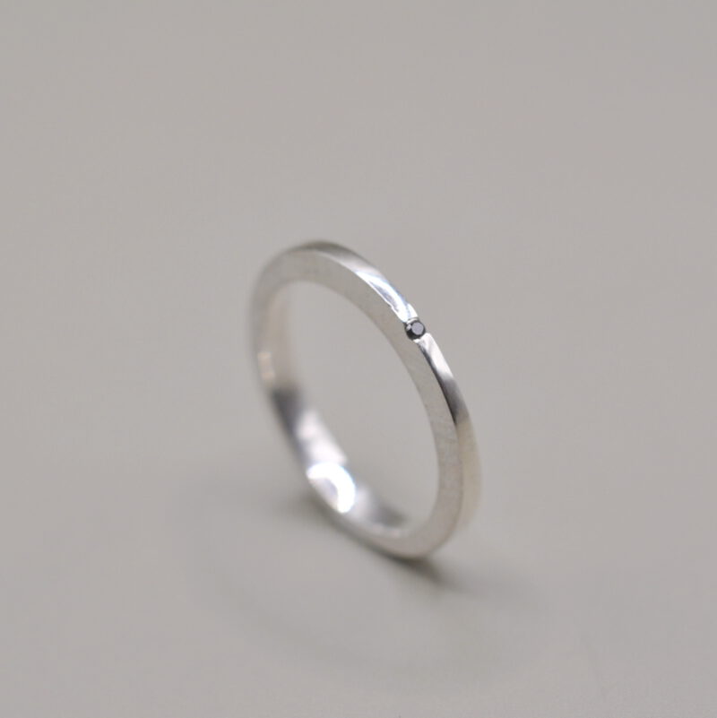 Silberner Ring Verformt mit einem kleinen schwarzen Diamant
