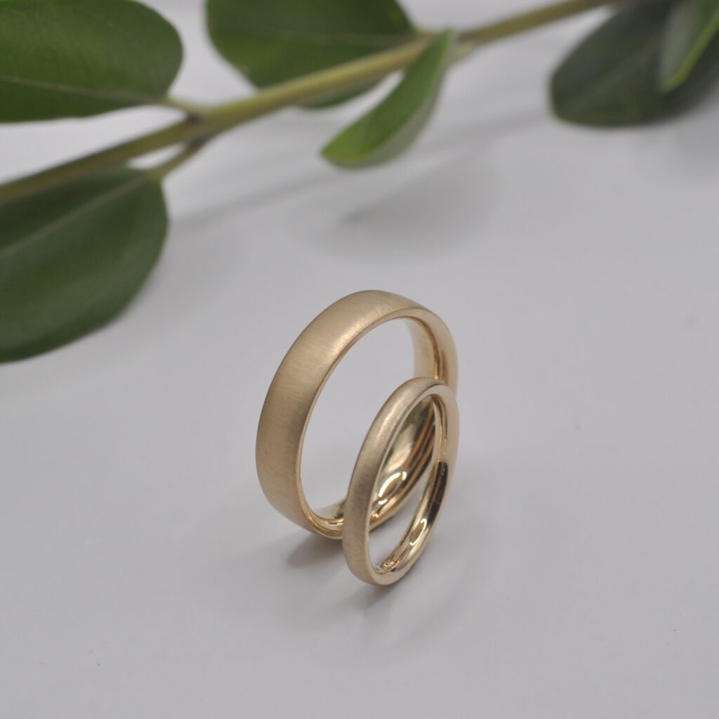 Trauringe aus Rosegold, breiter Herrenring und schmaler Damenring