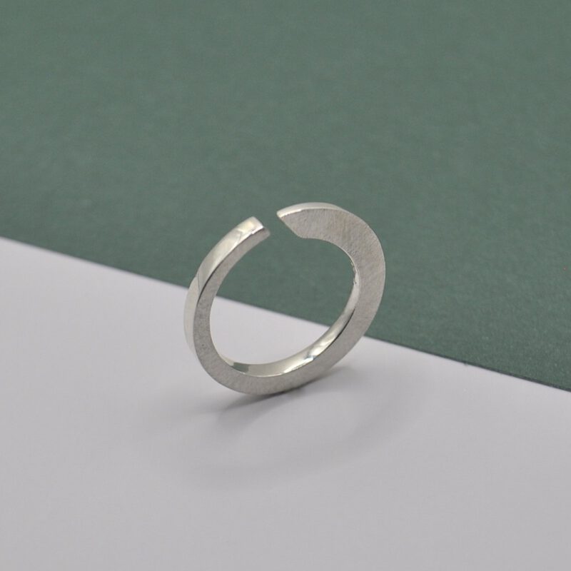 Querschnittsverformter Ring mit schräger Öffnung aus Silber