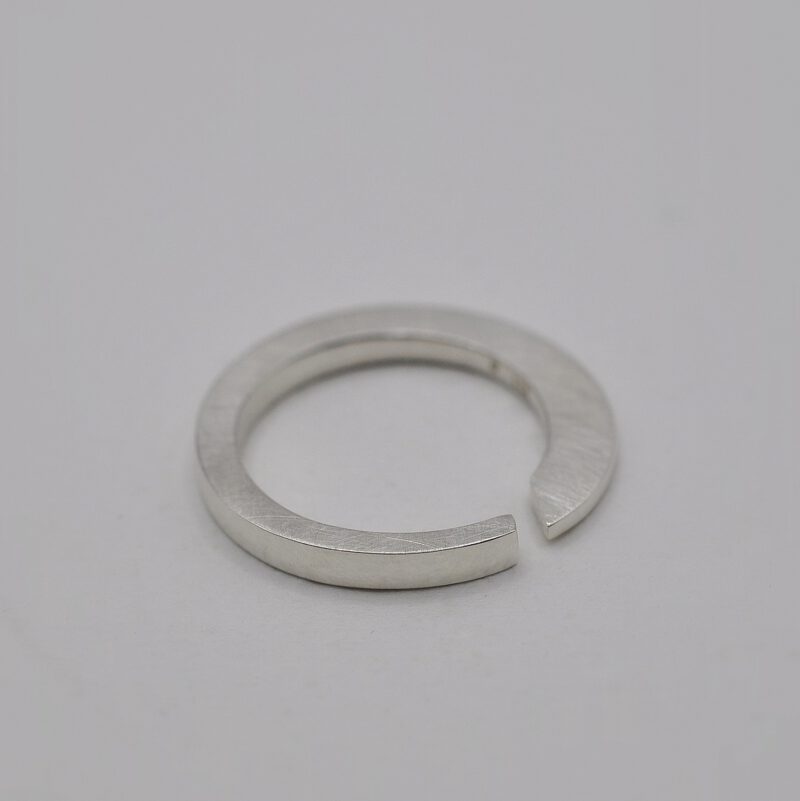 Querschnittsverformter Ring mit schräger Öffnung aus Silber