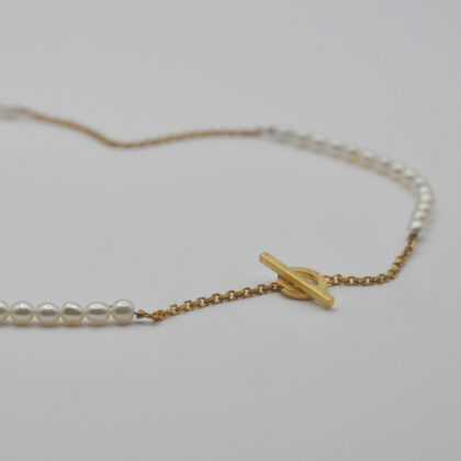 Vergoldete Kette, bei der sich kleine Barockperlen abwechseln mit einer funkelnden Ankerkette