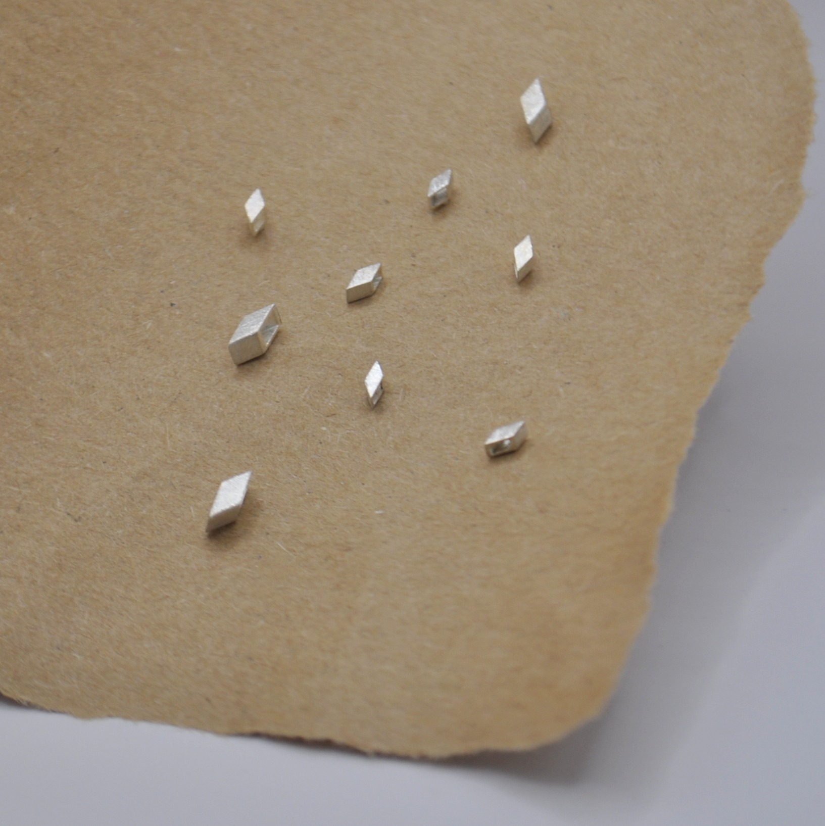 Diverse silberne Ohrstecker in zwei verschiedenen Größen. Rautenförmig, aus quadratischem Rohr.