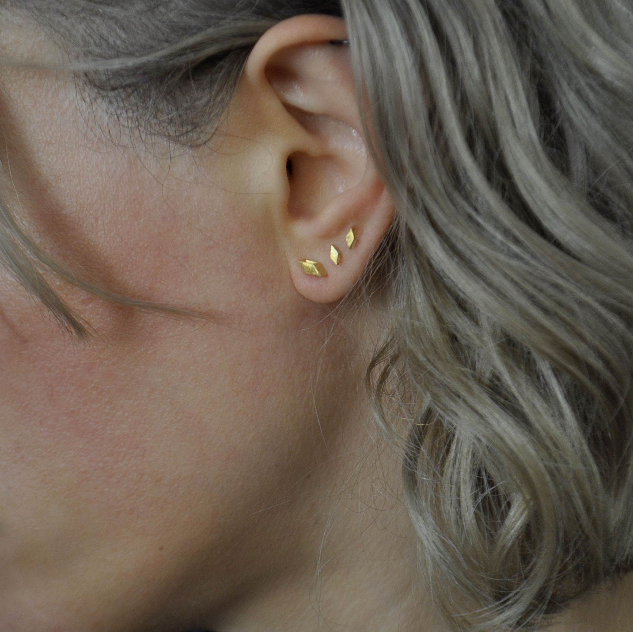 Drei Ohrstecker aus vergoldetem Silber in Form von abgeschrägten Quadraten