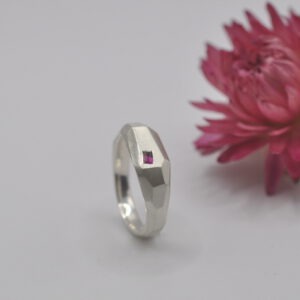 Ring "Erstarrt" mit Flächen und Facetten. Ein eingefasster Rubin und ein Saphir.