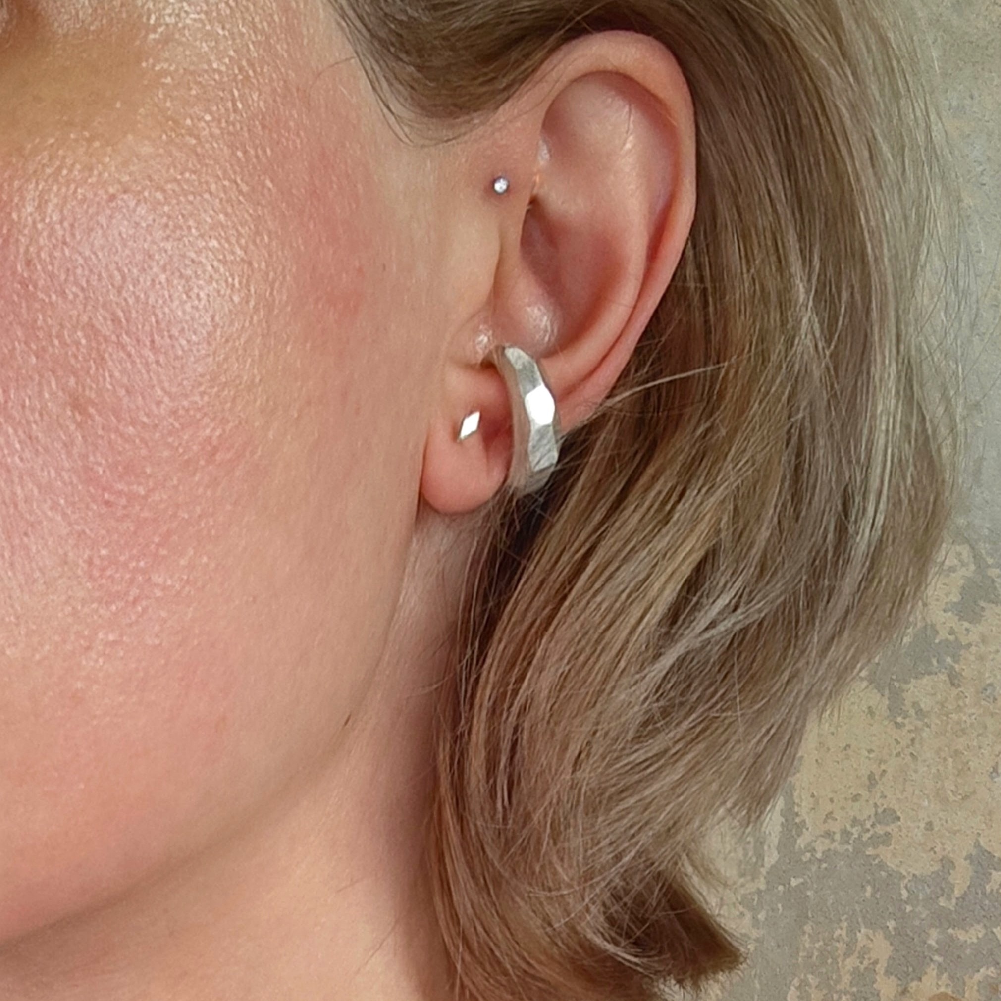 Seidenmatter Earcuff mit unregelmäßigen Facetten am Ohr einer Frau